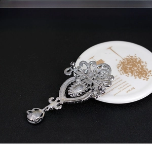 Macro detail of crown brooch back showing durable pin structure and versatile pendant loop