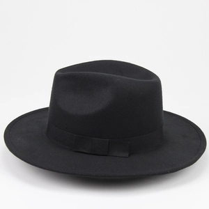 Detail of the black fedora hat showing wide brim and grosgrain ribbon with flat bow