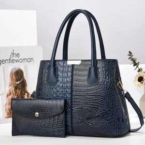 Deep blue croc-embossed tote bag set with matching wallet on a minimalist desk