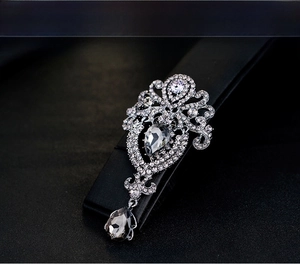 Macro shot of baroque crown brooch with grey waterdrop crystals and silver carvings