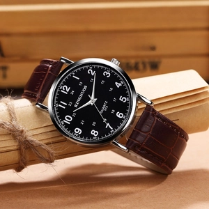 Detail shot of brown leather strap quartz watch with black dial and white numbers