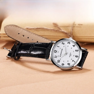 Macro view of KINGNUOS quartz watch with silver case and white dial on a vintage background