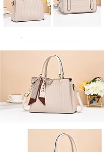 Detail of cream white handbag with vertical striped embossing and silk scarf accent