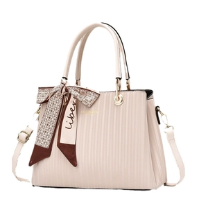 Beige pleated leather tote bag with printed scarf and adjustable crossbody strap