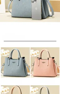 Close-up of textured leather handbag with Fashion Queen logo and removable metal shoulder strap