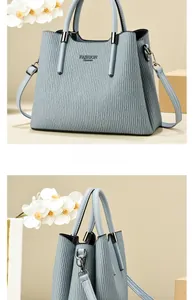 Detail view of grey-blue pleated handbag showing vertical texture and Fashion Queen print