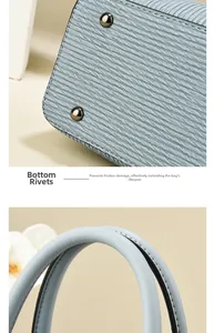 Detail of light blue handbag featuring protective base rivets and textured wavy leather