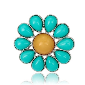 Detailed view of a flower brooch featuring turquoise stones and a yellow center on silver metal