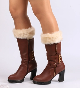 Detailed view of brown faux leather boots with white fur trim and side zipper detail