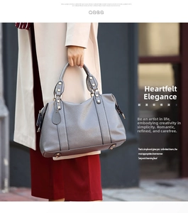 Close-up of grey pebbled leather Boston bag showing reinforced handles and elegant metal hardware