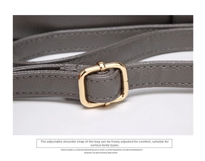 Detail of adjustable golden metal buckle on grey lychee texture leather shoulder strap