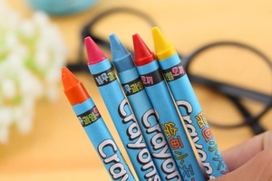 Close-up of five colorful wax crayons held by hand for kids' creative drawing and art
