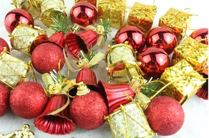 Macro view of festive red and gold Christmas ornaments on white faux fur background