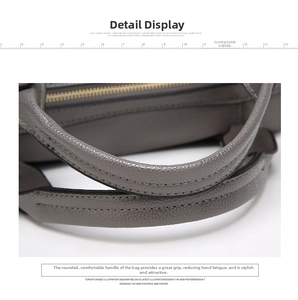 Close-up of grey pebbled leather handbag featuring rounded reinforced top handles
