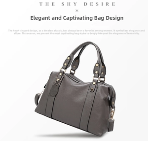 Close-up of grey litchi texture leather Boston bag with gold rivets and D-ring