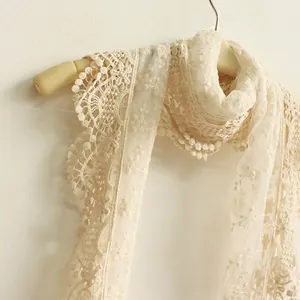 Elegant off-white lace scarf with floral crochet patterns and wavy edges on a wooden hanger