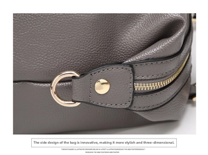 Detail view of grey lychee leather Boston bag featuring gold metal hardware and stitching