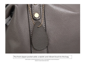 Detailed macro view of grey textured leather purse with decorative gold zipper and round metal ring