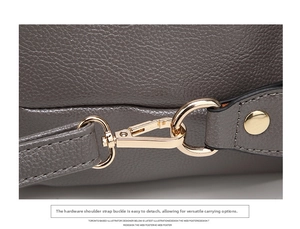 Close-up of grey litchi grain leather texture and light gold metal strap buckle
