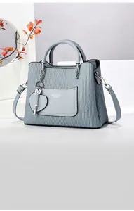 Détail du sac à main bleu clair avec pendentif en cœur et texture en cuir de vachette