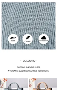 Détail de la texture ondulée et des anneaux métalliques argentés du sac à main femme