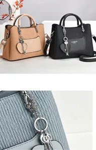Détail du sac en cuir PU plissé avec lettrage doré et breloque en forme de cœur élégante