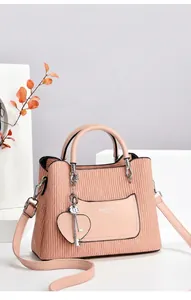 Détail de la texture ondulée verticale sur un sac à main bleu avec pendentif cœur