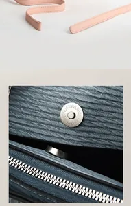 Détail du tissu bleu à texture ondulée avec boucle magnétique argentée et zip métallique