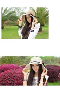 Detailed texture of beige woven straw sun hat with black ribbon bow decoration