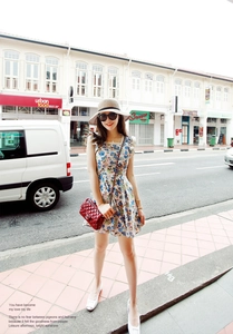Detail showing high-quality straw hat texture and blue floral dress on a street