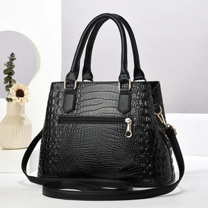 Detail of classic black faux crocodile pattern leather with gold metal zipper and hardware