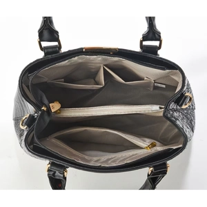 Detailed interior of black faux crocodile handbag with gold hardware and multiple sections