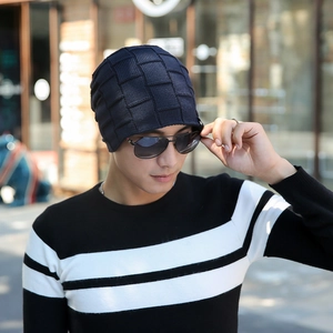 Outdoor view of dark blue knit beanie featuring textured square weave for winter warmth