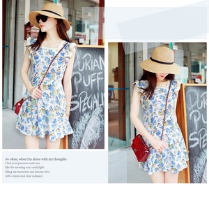 Detail of blue floral dress with ruffle cuffs and a wide-brimmed straw beach sun hat