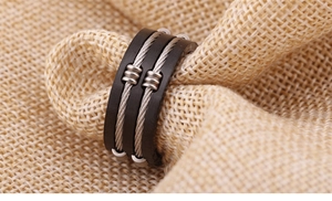 Macro detail of industrial 8mm titanium steel ring with silver cable inlay on burlap