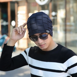 Macro detail of navy blue knitted beanie with checkered pattern and black patch label