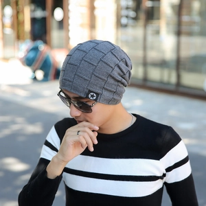 Detail of grey knitted winter beanie featuring a waffle texture and a star patch