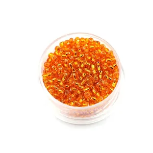 Orange 2mm glass seed beads with silver lining in a clear round container for DIY crafts