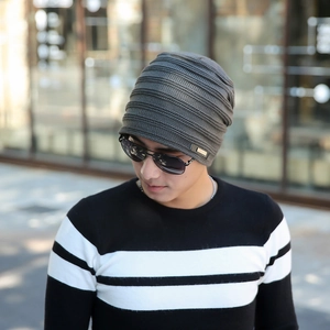 Dark grey knitted beanie for men with warm fleece lining in a street style outdoor view