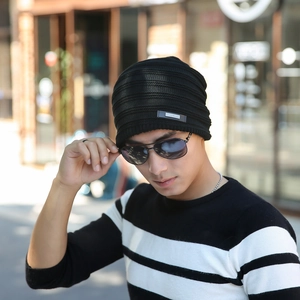Close-up of black ribbed knit beanie featuring a small metallic fashion logo detail