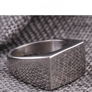 Macro shot of silver square ring with S925 hallmark on minimalist stainless steel band