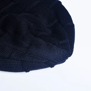 Close-up of black coarse knit beanie featuring detailed grid weave texture and warm lining