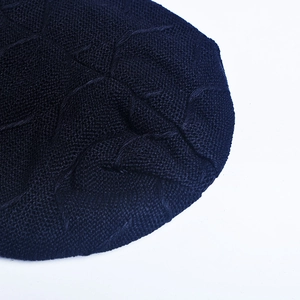 Close-up of dark knit beanie featuring detailed textured stitching and warm fabric