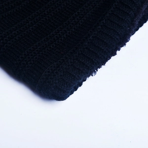 Detailed macro shot of the black ribbed knit fabric and texture on the winter beanie