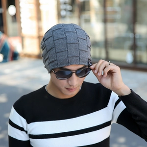 Detailed view of dark grey square-grid knit beanie with fleece lining on male model