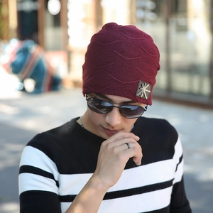 Detail of burgundy knitted beanie with warm fleece lining and star metal patch detail