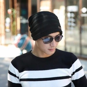 Close-up of black knitted beanie with a metal tag detail and warm fleece lining