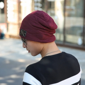 Close-up of burgundy knit beanie with star patch showing thick texture and fit