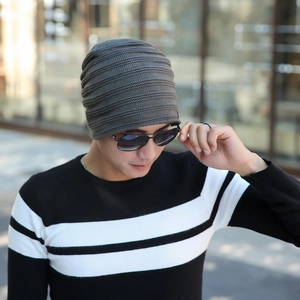 Outdoor close-up of charcoal grey ribbed knit beanie showing textured stripe pattern