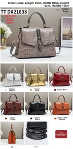 Detail view of crocodile pattern handbag showing multi-compartment dual zippers and base